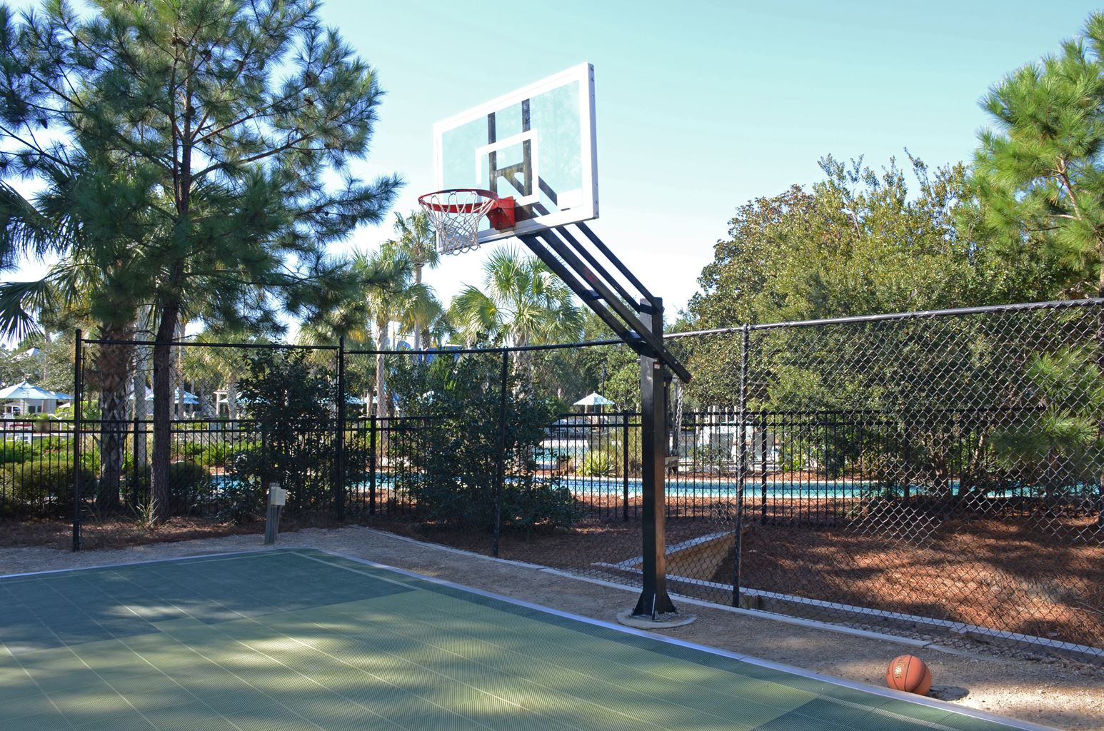 Close-up of the Camp WaterColor basketball hoop with pool in the background